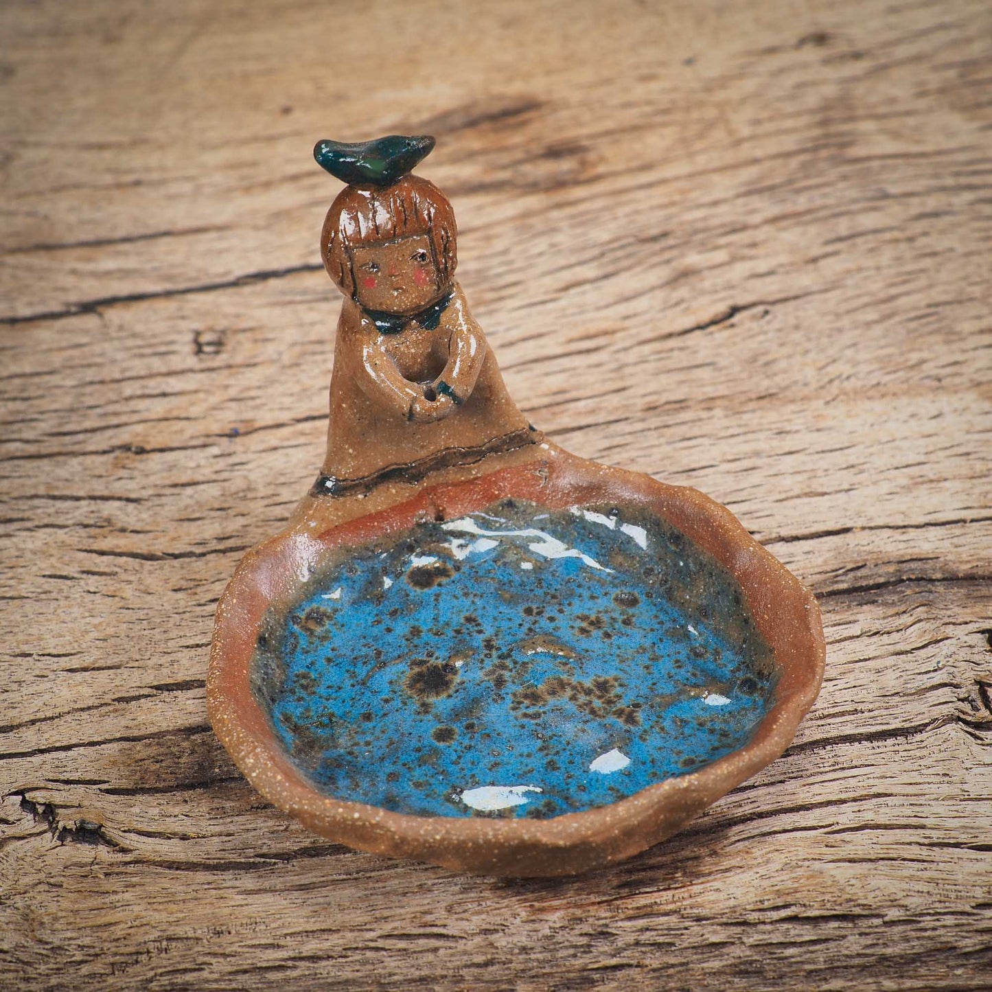 An original handmade ceramic girl with a bird on her head by Idania Salcido AKA Danita Art. She is perfect for storing jewelry, rings, and keys in her blue tray
