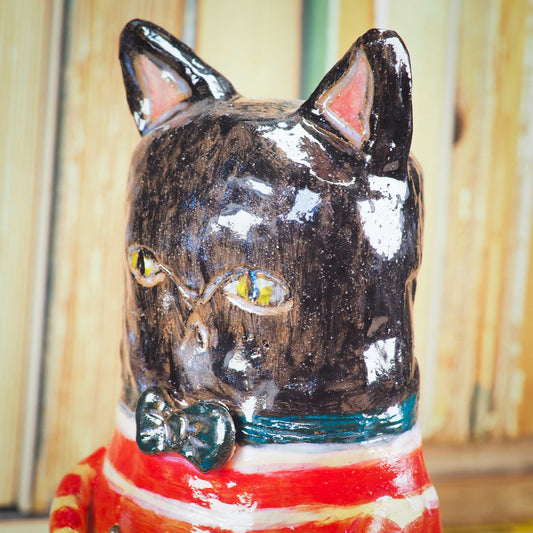 A handmade ceramic cat that loves fish... and mermaids! He is holding a cute little blond mermaid in his paws. Original ceramic sculpture by Idania Salcido.