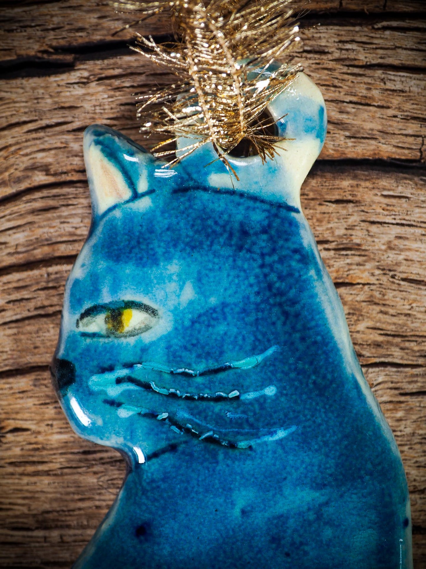 Handmade ceramic blue cat ornament with painted face and curled tail, created by Idania Salcido Danita Art for holiday decoration or gifting.
