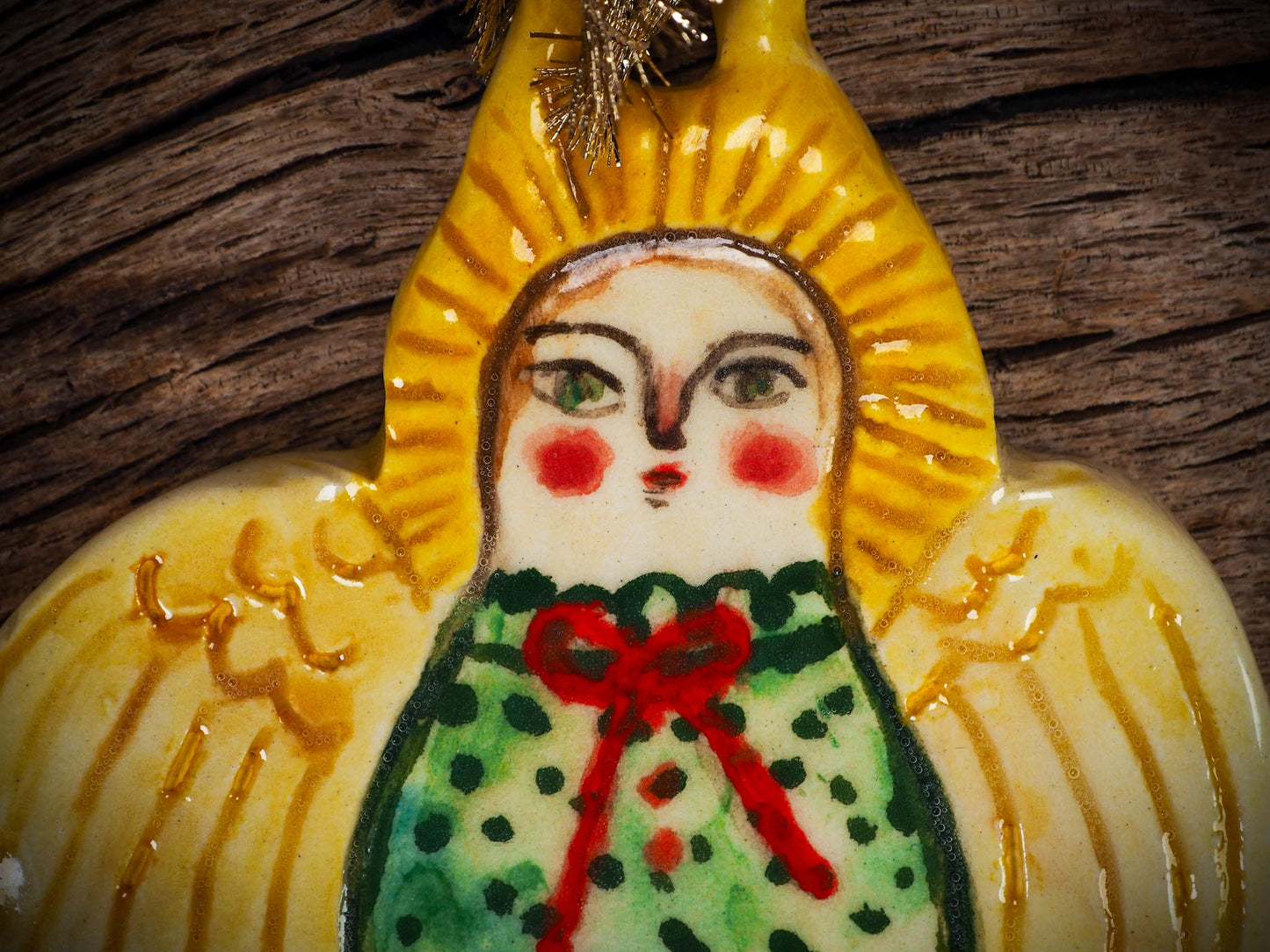Handmade ceramic angel ornament with painted face, wings, and halo, created by Idania Salcido Danita Art for Christmas decorating or gifting.