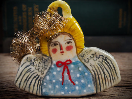 Handmade ceramic angel ornament with painted face, wings, and halo, created by Idania Salcido Danita Art for Christmas decorating or gifting.