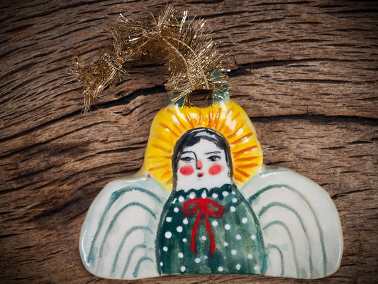 Handmade ceramic angel ornament with painted face, wings, and halo, created by Idania Salcido Danita Art for Christmas decorating or gifting.
