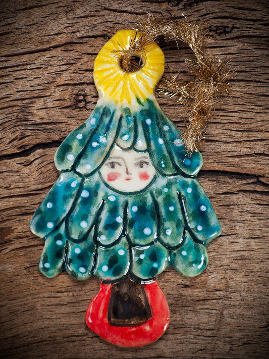 Handmade ceramic Christmas tree figure ornament with painted face and snowy details, created by Idania Salcido Danita Art for holiday decoration or gifting.