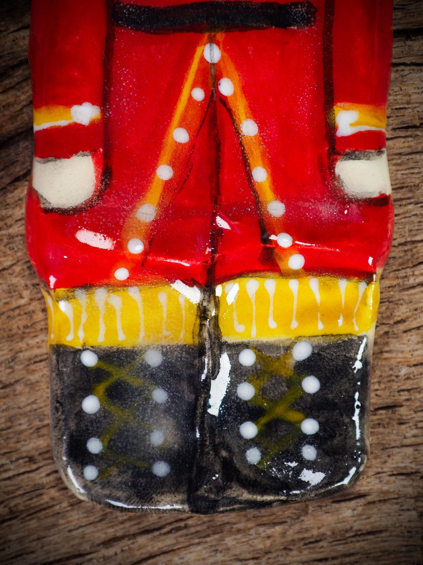 Handmade ceramic nutcracker ornament with red uniform and ribbon, created by Idania Salcido Danita Art for Christmas decoration or gifting.
