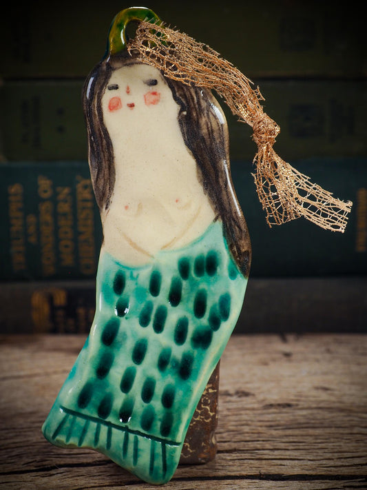 Handmade ceramic mermaid ornament with golden hair and blue-green tail, created by Idania Salcido aka Danita Art for holiday decorating or gifting.