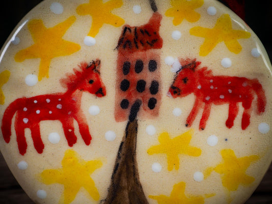 Handmade ceramic folk animals ornament with red animals, yellow stars, and small house, created by Idania Salcido aka Danita Art for Christmas decorating or gifting.