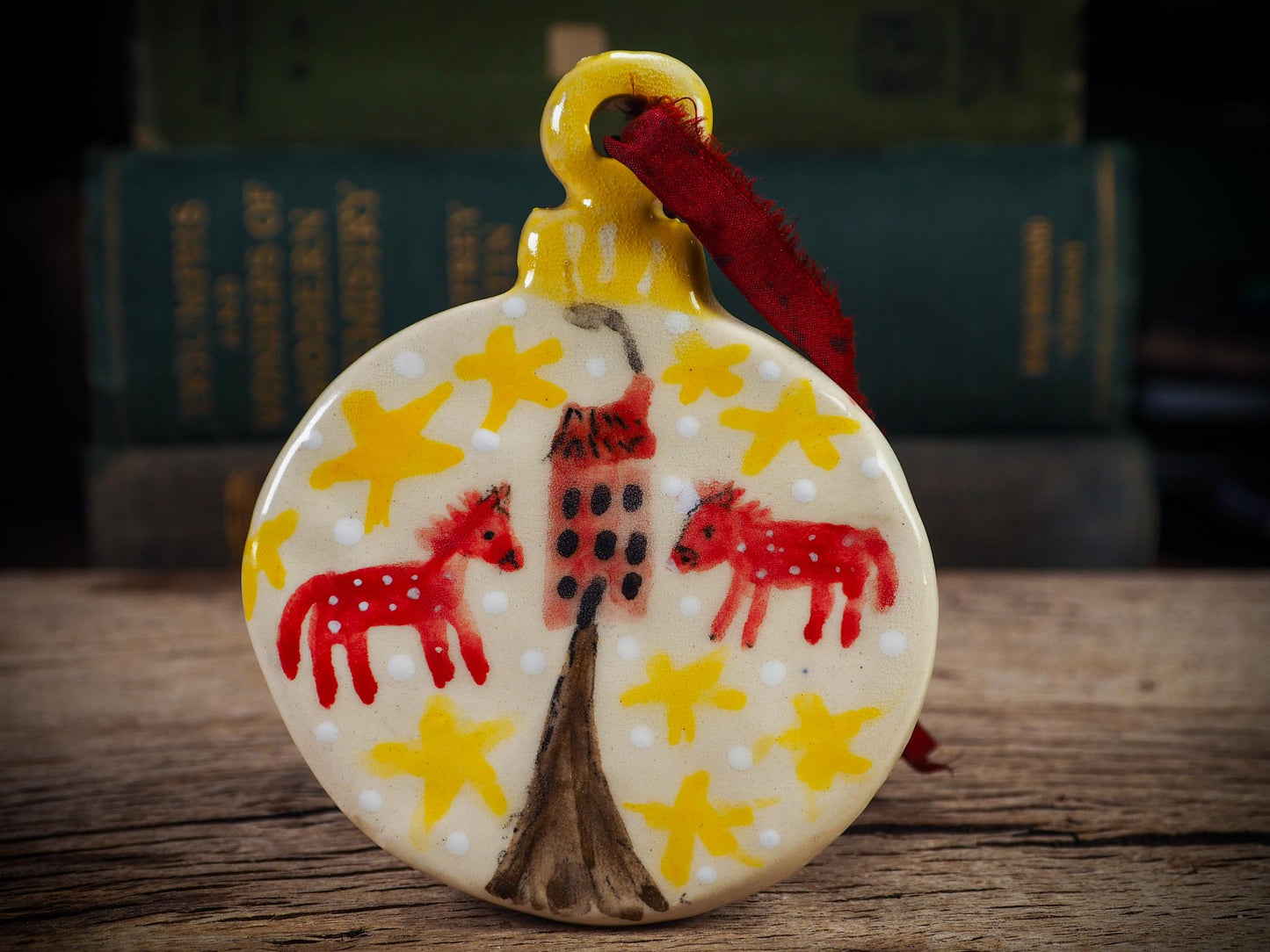 Handmade ceramic folk animals ornament with red animals, yellow stars, and small house, created by Idania Salcido aka Danita Art for Christmas decorating or gifting.