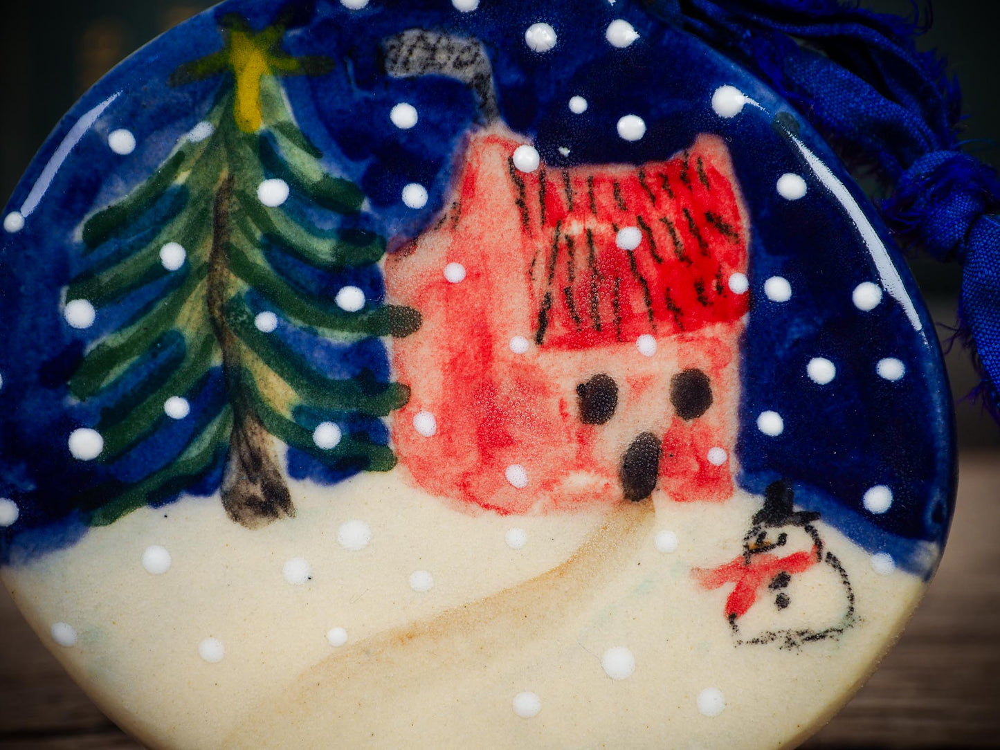 Handmade ceramic winter cottage ornament with snowman and tree, created by Idania Salcido aka Danita Art for Christmas decorating or gifting.