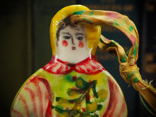 Handmade ceramic winter figure ornament with green dress and painted details, created by Idania Salcido aka Danita Art for Christmas decoration or gifting.