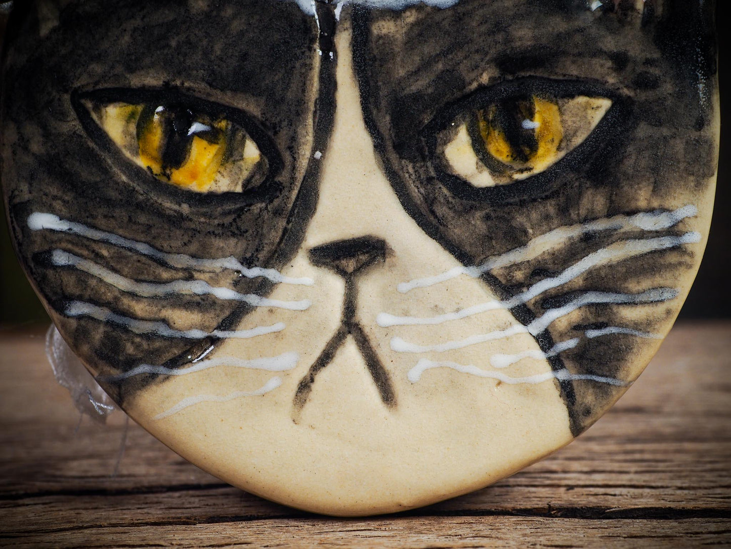 Handmade ceramic black and white tuxedo cat ornament with red holiday hat and ribbon, created by Idania Salcido Danita Art for Christmas decoration or gifting.