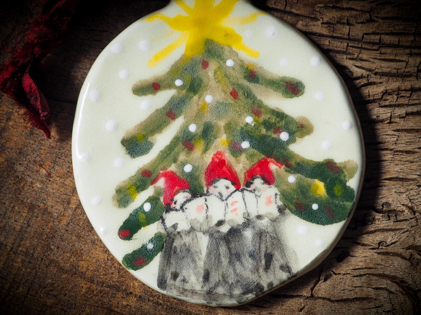 Handmade ceramic ornament of carolers under a Christmas tree by Idania Salcido aka Danita Art.