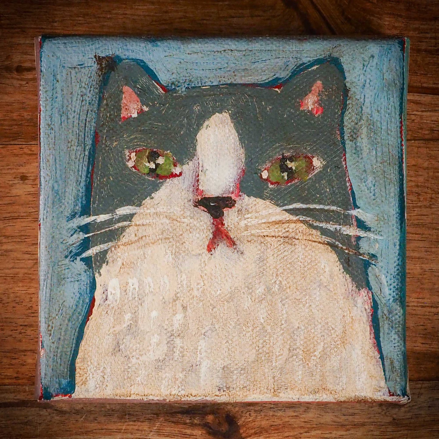 An original acrylic painting by Idania Salcido, Danita Art, depicting a grey cat posing on a serious pose. A cat doing cat things.