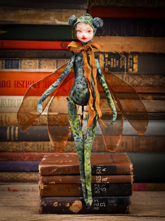 Each doll by Idania Salcido, the artist behind Danita Art is made with hand dyed fabric that I prepare myself, adorned with a lush set of mica wings and a silky ribbon, she is a beautiful dragonfly ready to take flight. Approximately 12 Inches tall. Original art doll in hand dyed fabric with natural pigments, polymer clay face and mixed media applications.