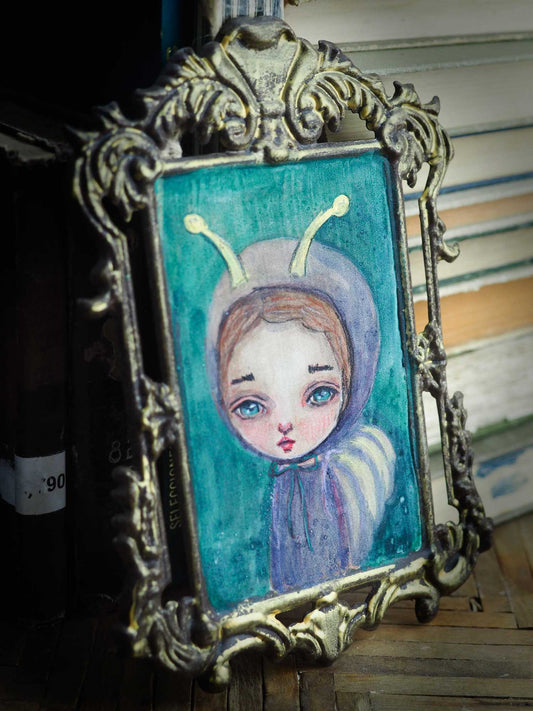 A beautiful mini-painting by Danita Art, a surrealist woman dressed as a butterfly moth in a dreamy setting with purple colors.