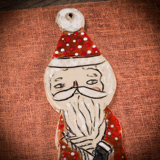 An original Christmas Holiday tree round glazed ceramic ornament handmade by Idania Salcido, the artist behind Danita Art. Glazed carved sgraffito stoneware, hand painted and decorated, it is illustrated by hand with snowmen, Christmas trees, Santa Claus, angels and snow balls and winter themes.
