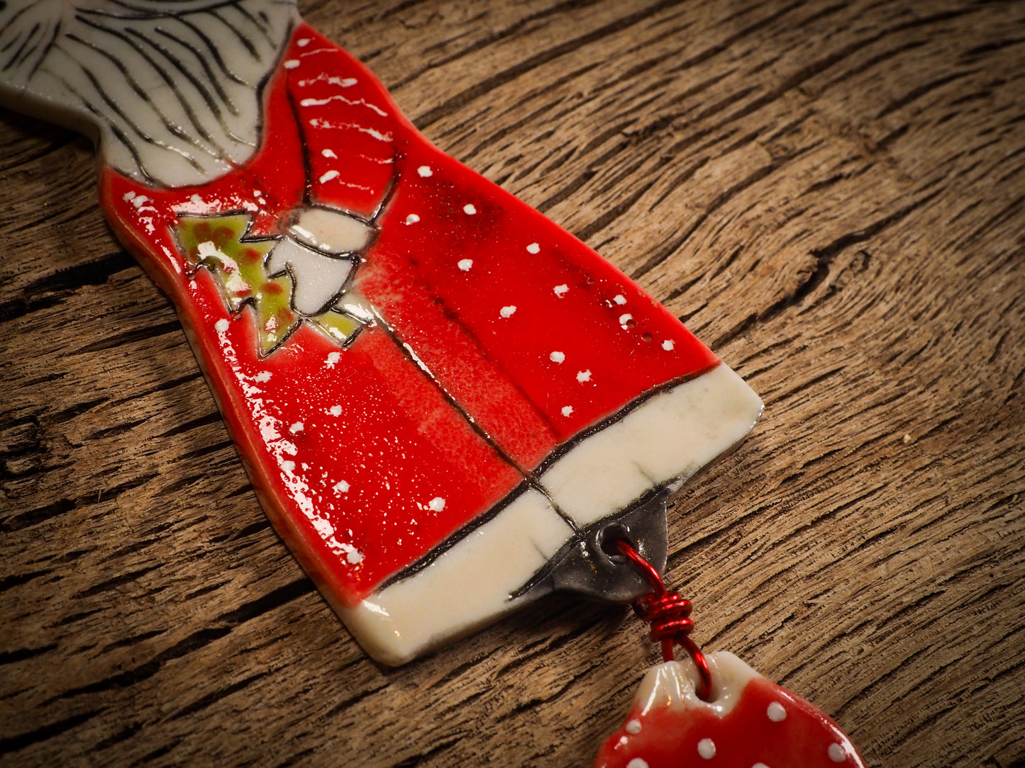 An original Christmas Holiday tree round glazed ceramic ornament handmade by Idania Salcido, the artist behind Danita Art. Glazed carved sgraffito stoneware, hand painted and decorated, it is illustrated by hand with snowmen, Christmas trees, Santa Claus, angels and snow balls and winter themes.