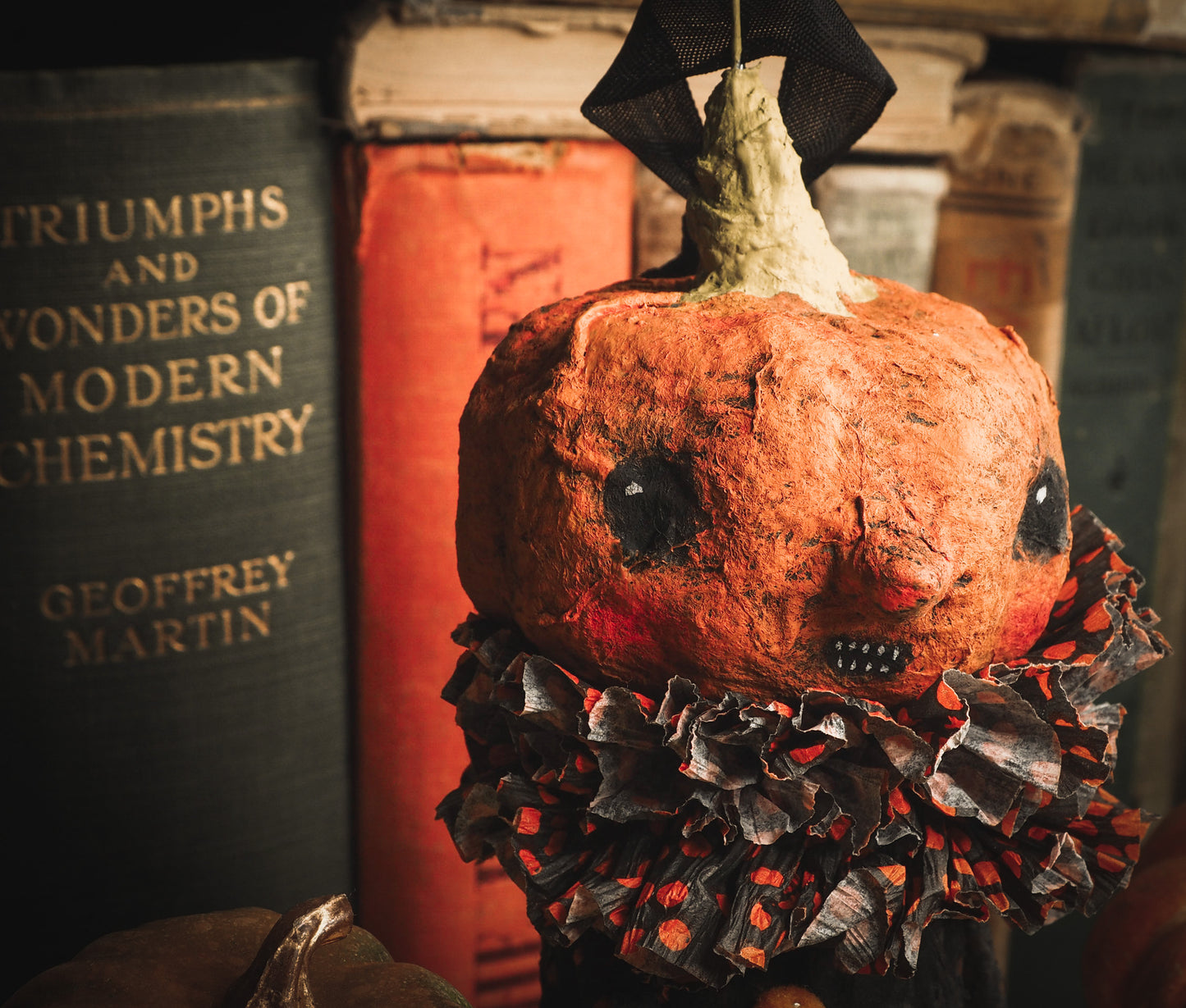 This adorable Halloween handmade ornament pumpkin jack-o-lantern doll monster by Idania Salcido, the artist behind Danita Art, is made with painted spun cotton and paper. It has hand painted face, teeth and eyes with a glittery paper had and matching paper costume. A Halloween home decoration on trick-or-treat night.