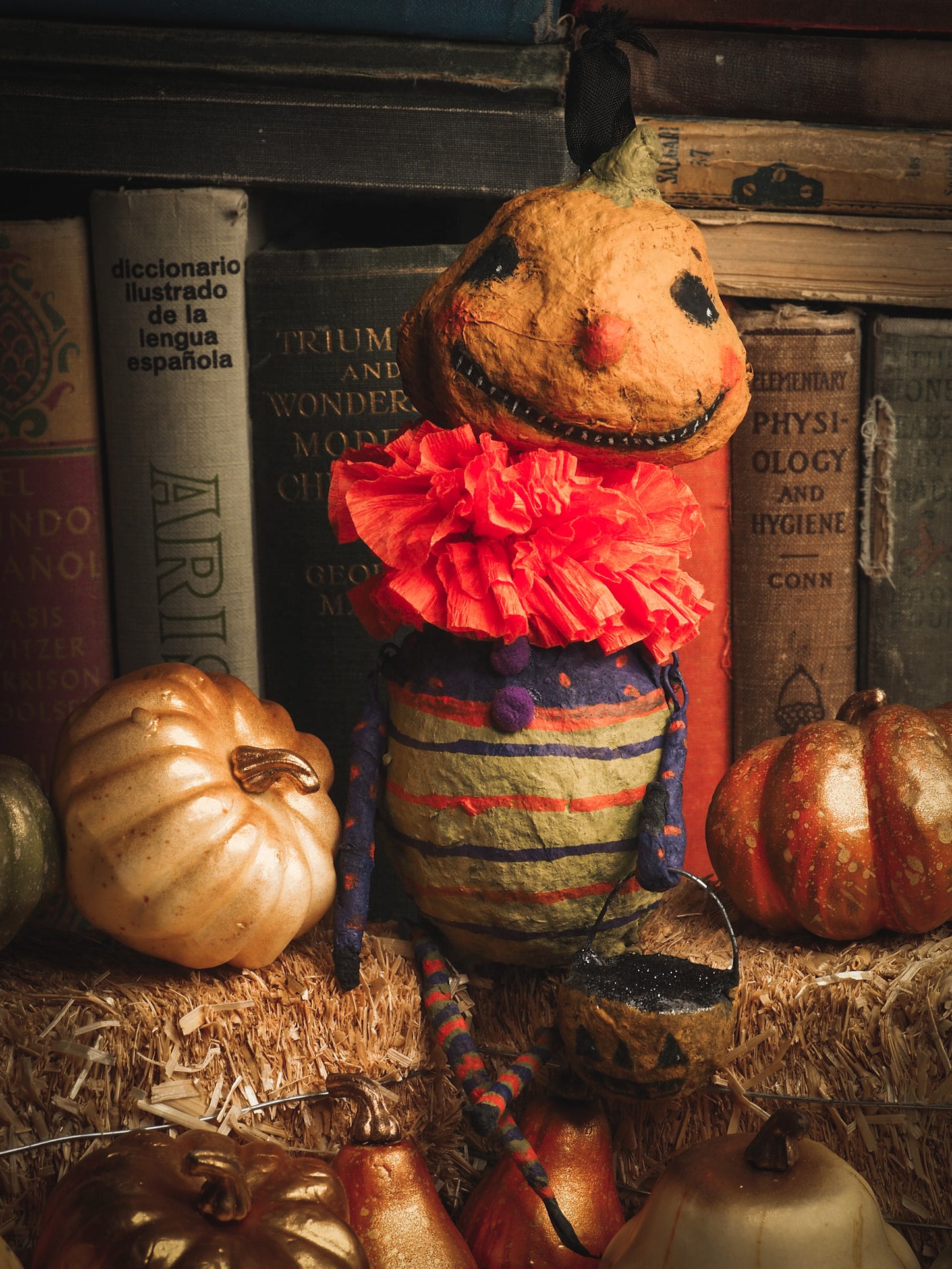 This adorable Halloween handmade ornament pumpkin jack-o-lantern doll monster by Idania Salcido, the artist behind Danita Art, is made with painted spun cotton and paper. It has hand painted face, teeth and eyes with a glittery paper had and matching paper costume. A Halloween home decoration on trick-or-treat night.