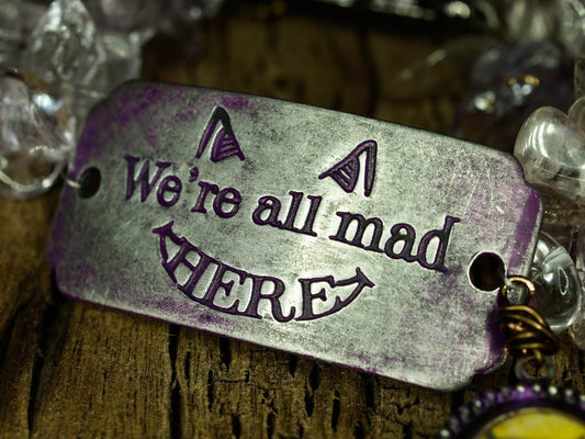 The cheshire cat lives again on this beautiful handmade bracelet with metal, glass and wire wrap jewelry work by Danita Art