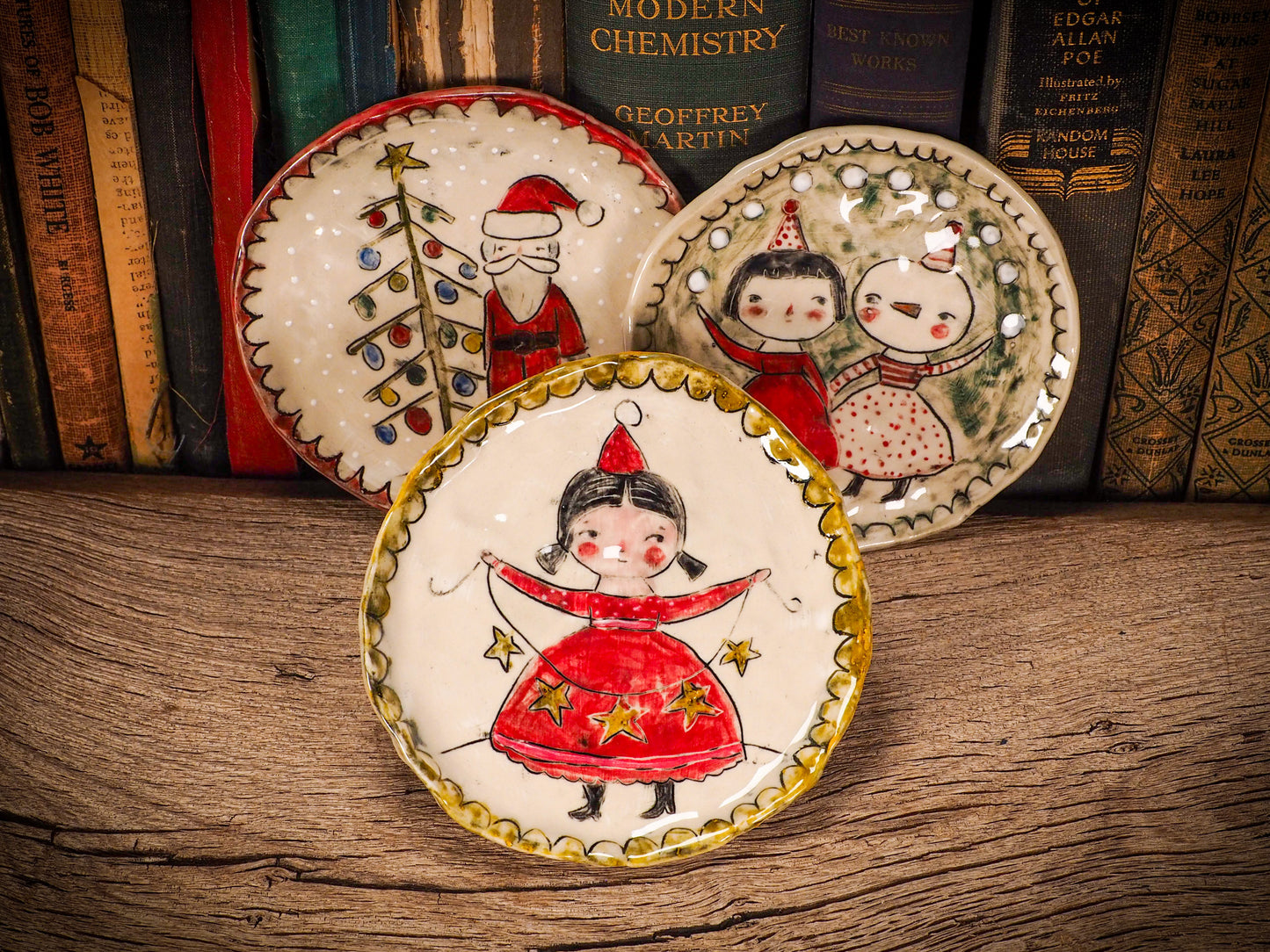 An original Christmas Holiday cake dinner plate round glazed ceramic dinnerware handmade by Idania Salcido, the artist behind Danita Art. Glazed carved sgraffito stoneware, hand painted and decorated, it is illustrated by hand with snowmen, Christmas trees, Santa Claus, angels and snow balls and winter themes.