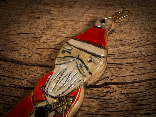 An original Christmas Holiday tree round glazed ceramic ornament handmade by Idania Salcido, the artist behind Danita Art. Glazed carved sgraffito stoneware, hand painted and decorated, it is illustrated by hand with snowmen, Christmas trees, Santa Claus, angels and snow balls and winter themes.