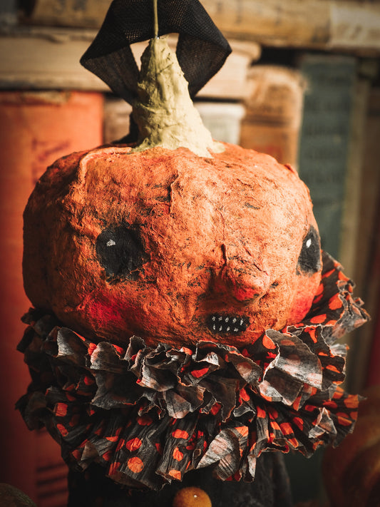 This adorable Halloween handmade ornament pumpkin jack-o-lantern doll monster by Idania Salcido, the artist behind Danita Art, is made with painted spun cotton and paper. It has hand painted face, teeth and eyes with a glittery paper had and matching paper costume. A Halloween home decoration on trick-or-treat night.