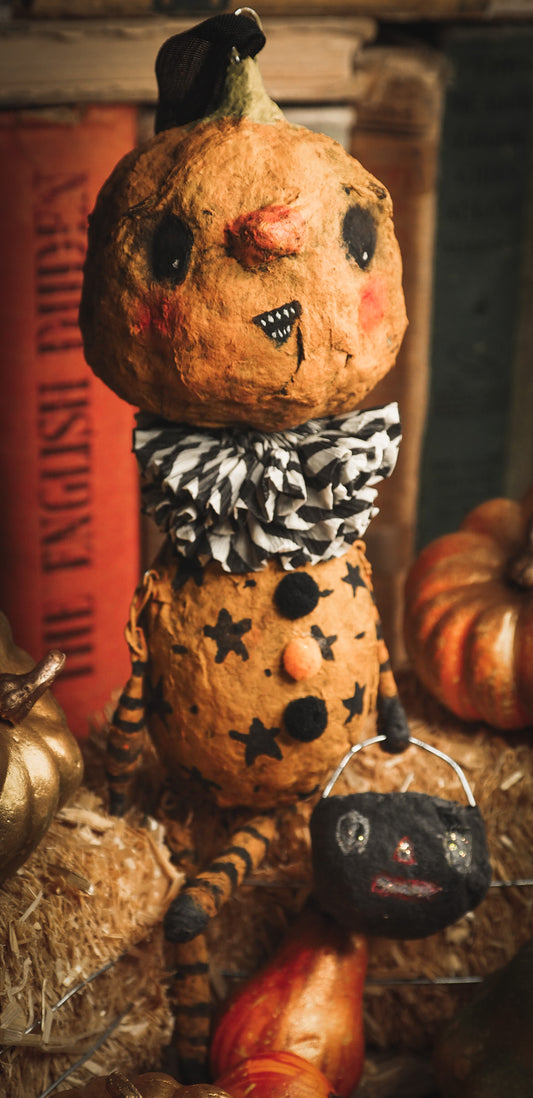 This adorable Halloween handmade ornament pumpkin jack-o-lantern doll monster by Idania Salcido, the artist behind Danita Art, is made with painted spun cotton and paper. It has hand painted face, teeth and eyes with a glittery paper had and matching paper costume. A Halloween home decoration on trick-or-treat night.