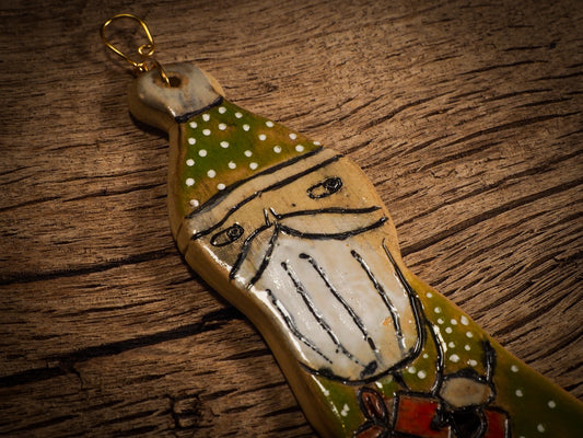 An original Christmas Holiday tree round glazed ceramic ornament handmade by Idania Salcido, the artist behind Danita Art. Glazed carved sgraffito stoneware, hand painted and decorated, it is illustrated by hand with snowmen, Christmas trees, Santa Claus, angels and snow balls and winter themes.