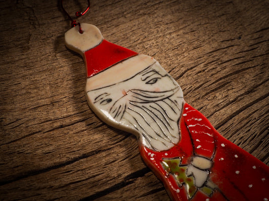 An original Christmas Holiday tree round glazed ceramic ornament handmade by Idania Salcido, the artist behind Danita Art. Glazed carved sgraffito stoneware, hand painted and decorated, it is illustrated by hand with snowmen, Christmas trees, Santa Claus, angels and snow balls and winter themes.