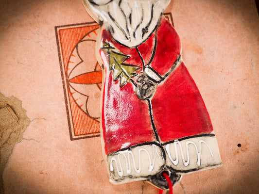 An original Christmas Holiday tree round glazed ceramic ornament handmade by Idania Salcido, the artist behind Danita Art. Glazed carved sgraffito stoneware, hand painted and decorated, it is illustrated by hand with snowmen, Christmas trees, Santa Claus, angels and snow balls and winter themes.