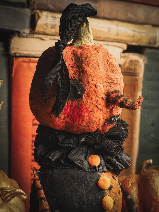 This adorable Halloween handmade ornament pumpkin jack-o-lantern doll monster by Idania Salcido, the artist behind Danita Art, is made with painted spun cotton and paper. It has hand painted face, teeth and eyes with a glittery paper had and matching paper costume. A Halloween home decoration on trick-or-treat night.