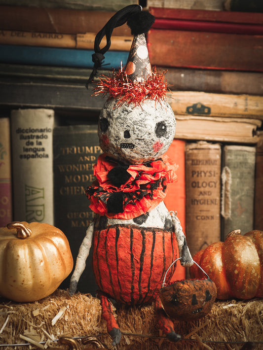 This adorable Halloween handmade ornament pumpkin jack-o-lantern doll monster by Idania Salcido, the artist behind Danita Art, is made with painted spun cotton and paper. It has hand painted face, teeth and eyes with a glittery paper had and matching paper costume. A Halloween home decoration on trick-or-treat night.