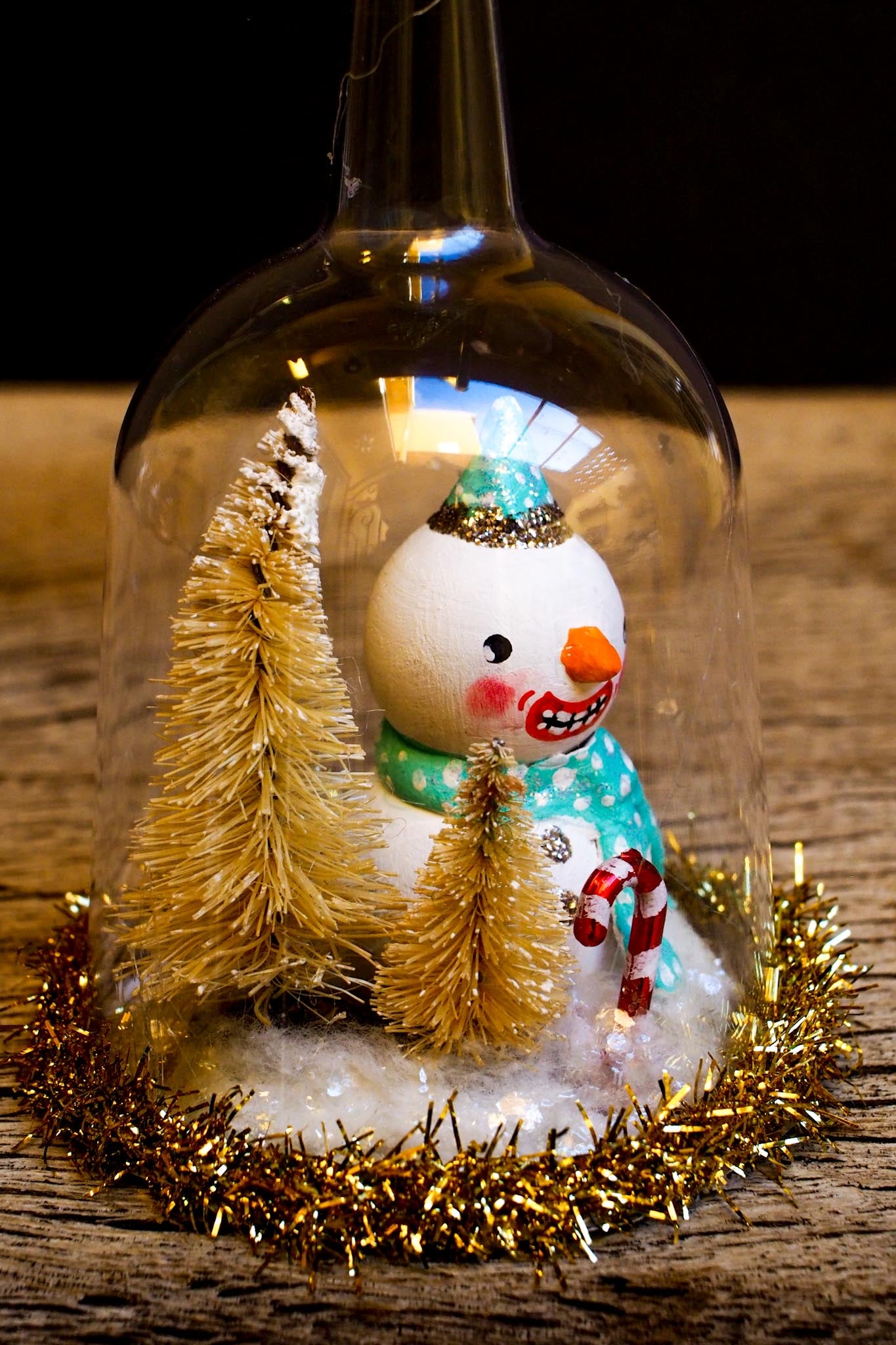 An original handmade christmas tree ornament by Idania Salcido. A clear domed diorama with a holiday scene with Santa Claus elves, Christmas Trees, Elves, Gifts and magical glitter deer. Perfect to decorate your Christmas Tree, your mantelpiece or to be used as accents on a dinner table.