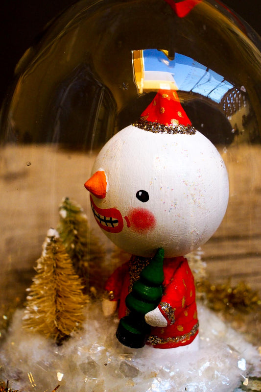 An original handmade christmas tree ornament by Idania Salcido. A clear domed diorama with a holiday scene with Santa Claus elves, Christmas Trees, Elves, Gifts and magical glitter deer. Perfect to decorate your Christmas Tree, your mantelpiece or to be used as accents on a dinner table.