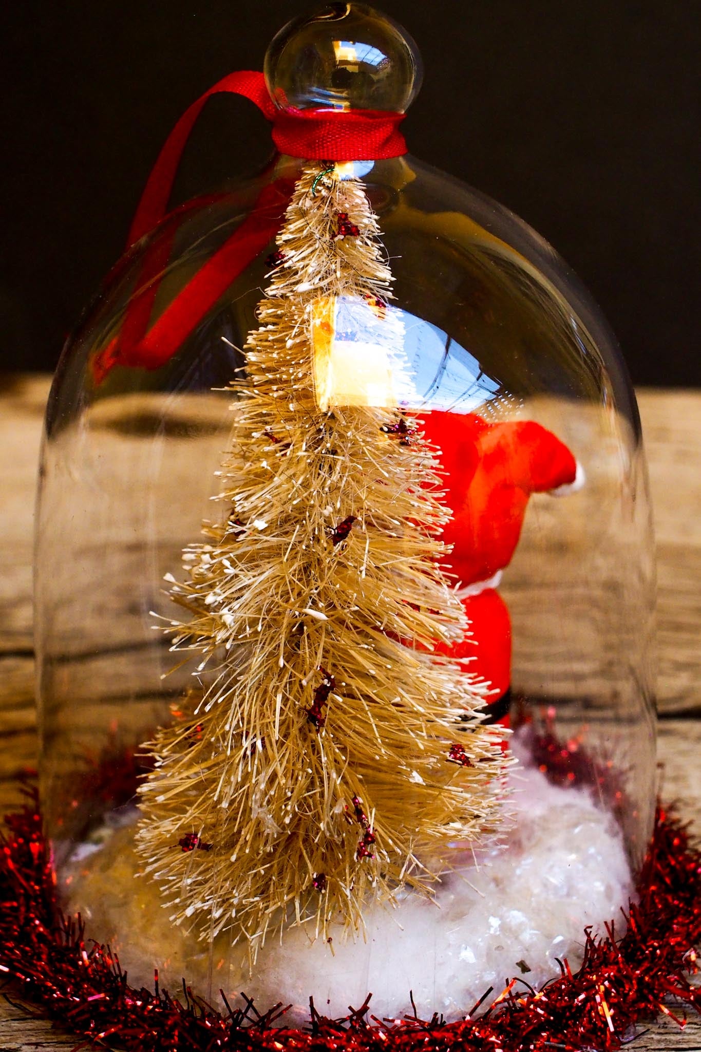 An original handmade christmas tree ornament by Idania Salcido. A clear domed diorama with a holiday scene with Santa Claus elves, Christmas Trees, Elves, Gifts and magical glitter deer. Perfect to decorate your Christmas Tree, your mantelpiece or to be used as accents on a dinner table.