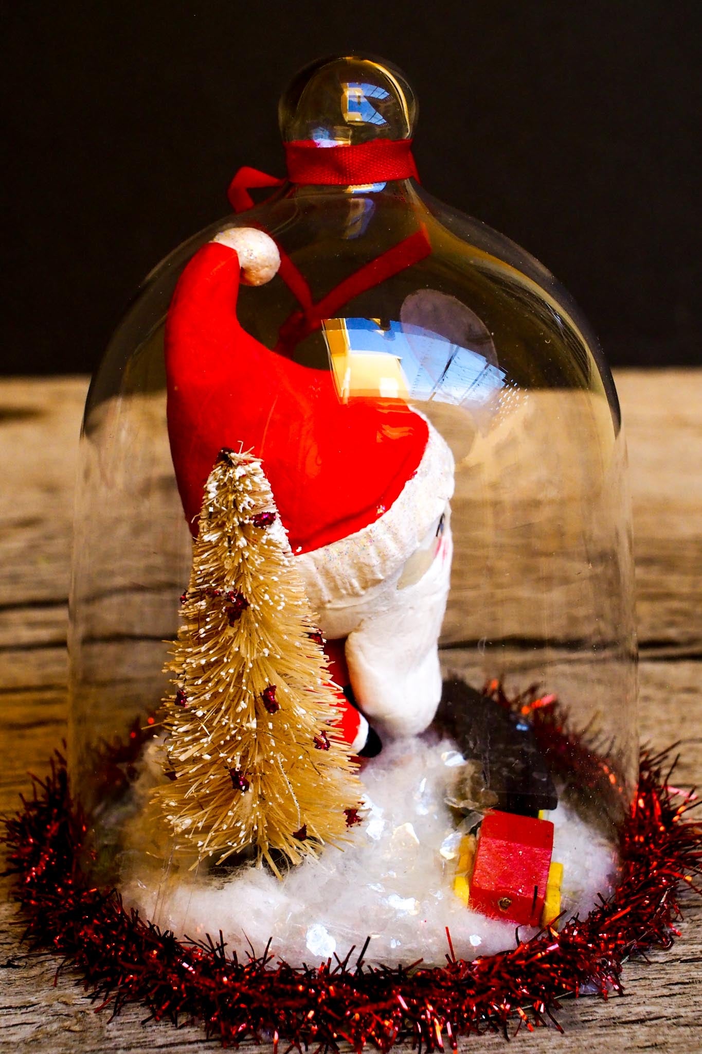 An original handmade christmas tree ornament by Idania Salcido. A clear domed diorama with a holiday scene with Santa Claus elves, Christmas Trees, Elves, Gifts and magical glitter deer. Perfect to decorate your Christmas Tree, your mantelpiece or to be used as accents on a dinner table.