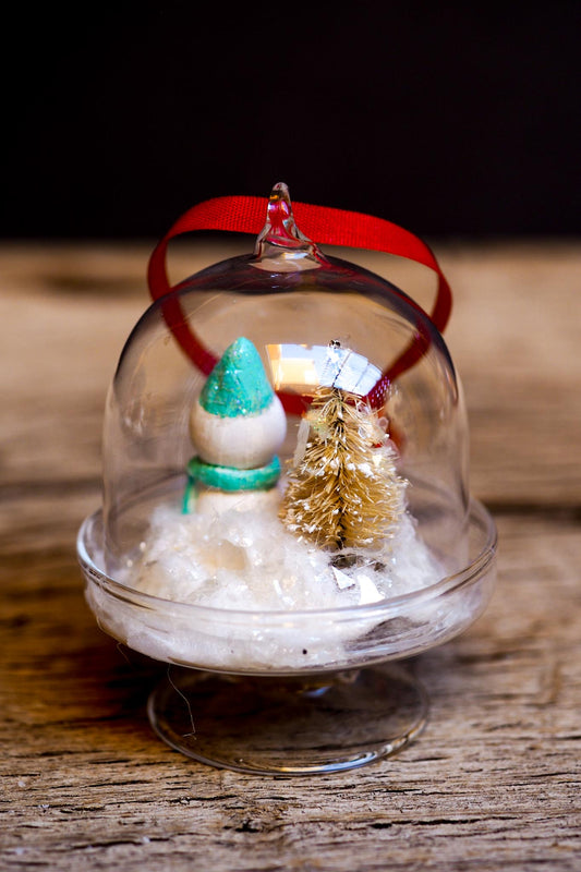 An original handmade christmas tree ornament by Idania Salcido. A clear domed diorama with a holiday scene with Santa Claus elves, Christmas Trees, Elves, Gifts and magical glitter deer. Perfect to decorate your Christmas Tree, your mantelpiece or to be used as accents on a dinner table.