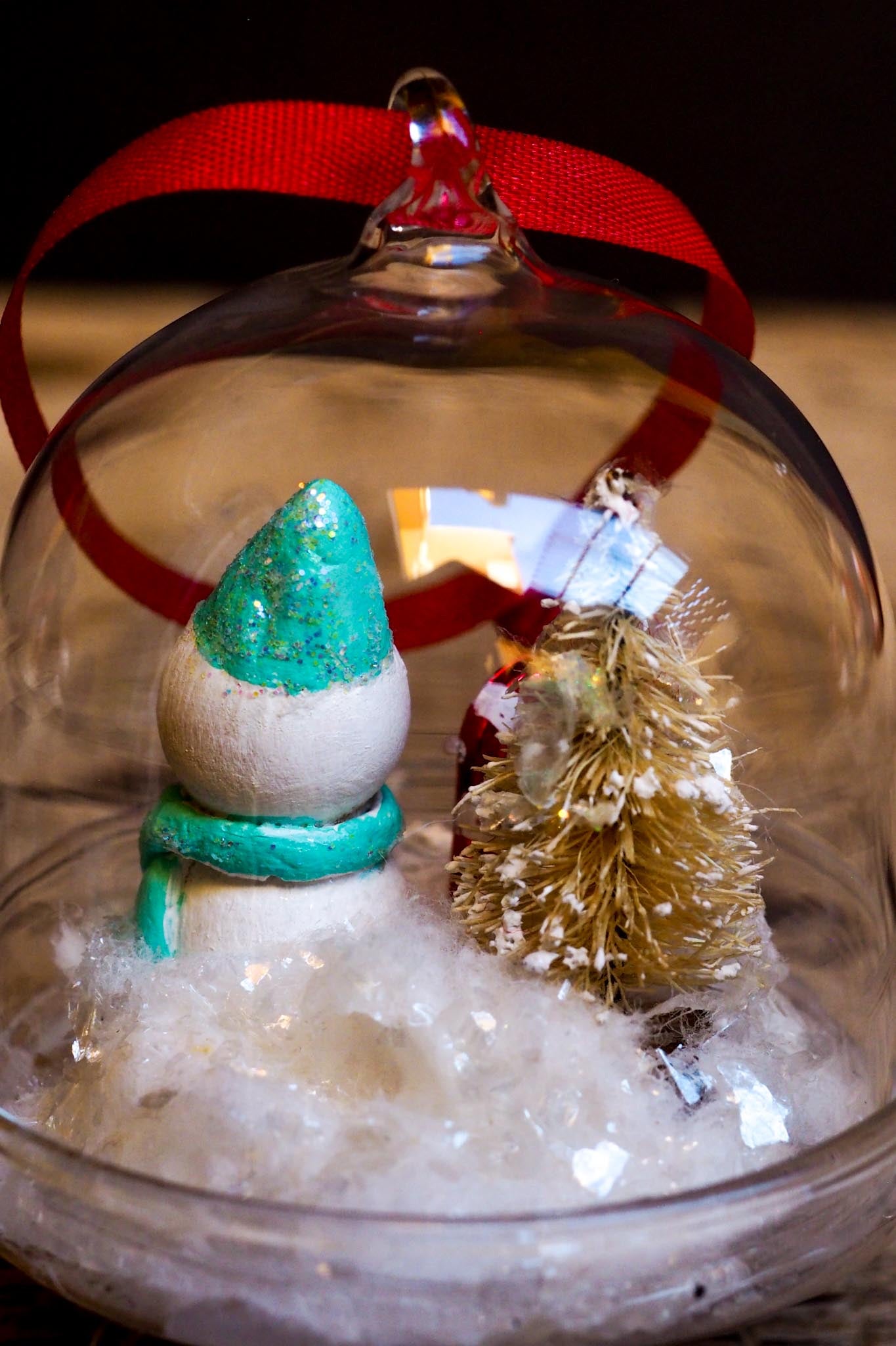 An original handmade christmas tree ornament by Idania Salcido. A clear domed diorama with a holiday scene with Santa Claus elves, Christmas Trees, Elves, Gifts and magical glitter deer. Perfect to decorate your Christmas Tree, your mantelpiece or to be used as accents on a dinner table.