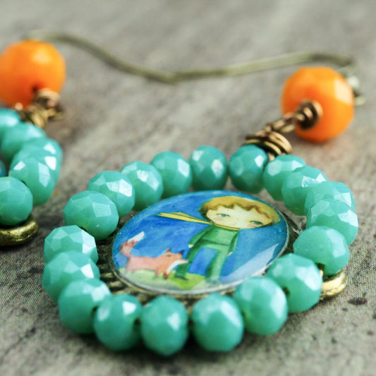 Original one of a kind earrings by Danita. The little prince is painted in the whimsical and surrreal style of Danita. One of a kind original accessories and wearable art.