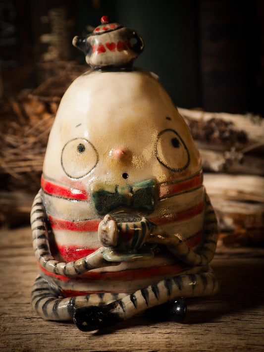 Humpty Dumpty vintage egg ceramic figure inspired by Alice in Wonderland made by Idania Salcido, the mixed media artist and ceramist behind Danita Art. Earth clay is hand sculpted and glazed and kiln fired to create a ceramic home decor heirloom figurine. Each unique art piece is a one of a kind fine pottery artwork.