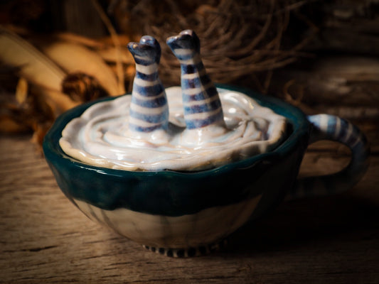 upside down tumbling Alice ceramic figure inspired by Alice in Wonderland made by Idania Salcido, the mixed media artist and ceramist behind Danita Art. Earth clay is hand sculpted and glazed and kiln fired to create a ceramic home decor heirloom figurine. Each unique art piece is a one of a kind fine pottery artwork.