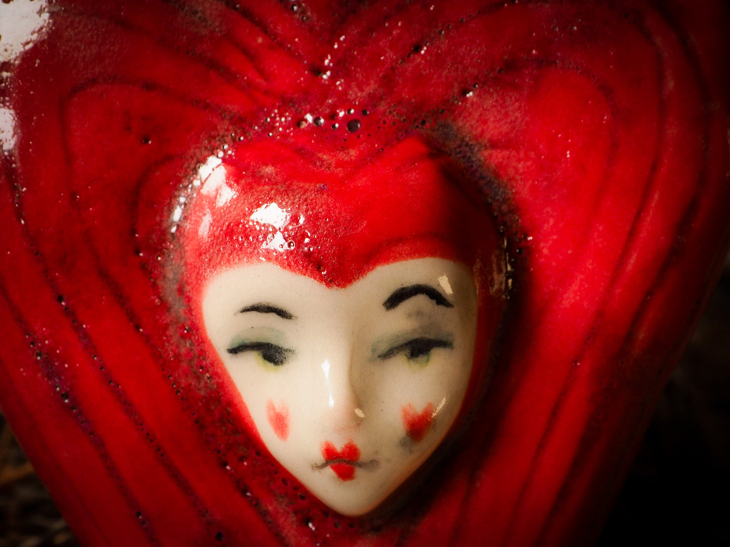 red burning heart glazed ceramic torso figure inspired by Alice in Wonderland by Idania Salcido, the artist behind Danita Art. Lumps of clay hand sculpted and glazed are kiln fired. Beautiful heart shaped wall hangings with nail hole in the back to place on wall with a hook or display on shelf or showcase.