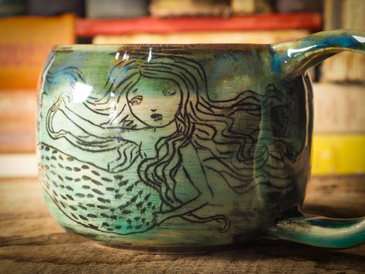 This is a handmade ceramic coffee or tea mug, create entirely by Idania Salcido, the artist behind Danita Art. The mermaid swimming on this mug is hand painted before glazing it and firing it on my very own kiln. It will be perfect for driving your favorite coffee or tea, in company of a beautiful mermaid.