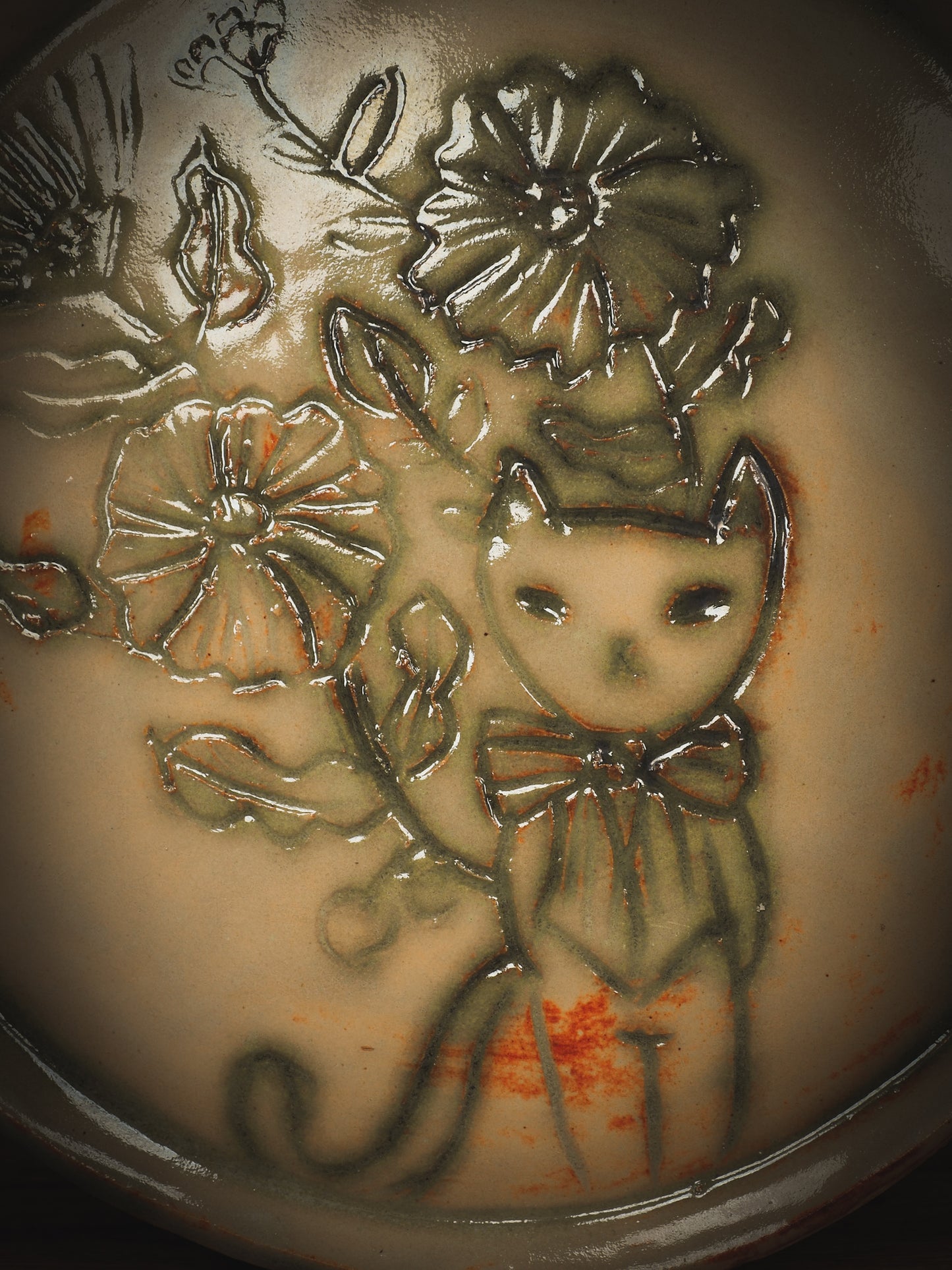 An original Idania Salcido Danita Art pinched ceramic cat pet food plate. Handmade from stoneware, this glazed ceramics one of a kind artwork is perfect for any kitchen plate and bowls unique collection. Thumbprints and intentionally irregular shape give the bowl a cozy, warmly familiar feel when you pick it. A cute little cat hiding in flowers is carved on the sides.