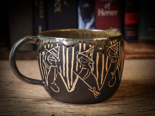 An original Halloween ceramic coffee mug bowl by Idania Salcido, the artist behind Danita Art. Made with wheel thrown clay, hand carved and glazed by the artist. The carved witches, ghosts, goblins and vampires give it a nice, folk art primitive feel to it. Perfect for Halloween Candy, ice cream and fruit and as pet cat bowl.