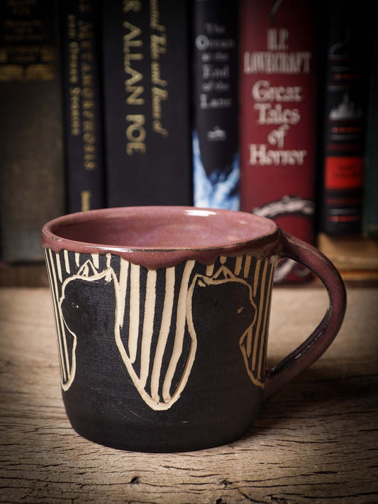 An original Halloween ceramic mug tumbler bowl handmade by Idania Salcido the artist behind Danita Art. Made with wheel thrown clay hand carved and glazed by the artist. Witches, ghosts, goblins, black cats, vampires give a folk art primitive feel to it. Perfect for Halloween Candy, ice cream and fruit, a pet cat bowl.