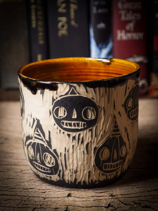 An original Halloween ceramic mug tumbler bowl handmade by Idania Salcido the artist behind Danita Art. Made with wheel thrown clay hand carved and glazed by the artist. Witches, ghosts, goblins, black cats, vampires give a folk art primitive feel to it. Perfect for Halloween Candy, ice cream and fruit, a pet cat bowl.