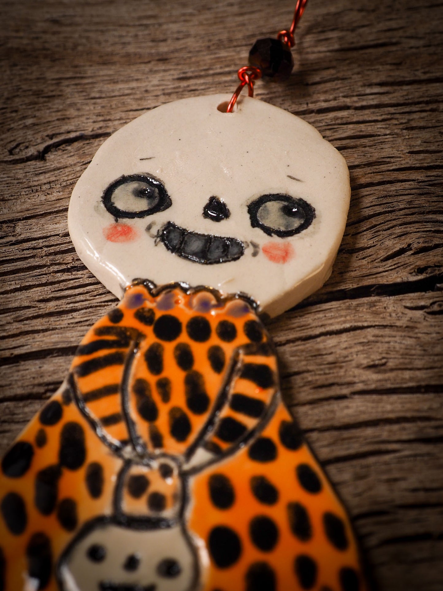 An original handmade Halloween ornament by Idania Salcido, Danita Art. Each ornament is hand carved with pumpkins, witches, cats, jack-o-lanterns and moons. Made with fired glazed ceramics, this little witch, jack-o-lantern and cat is carved with delicate patterns that make each ornament a one of a kind work of art.