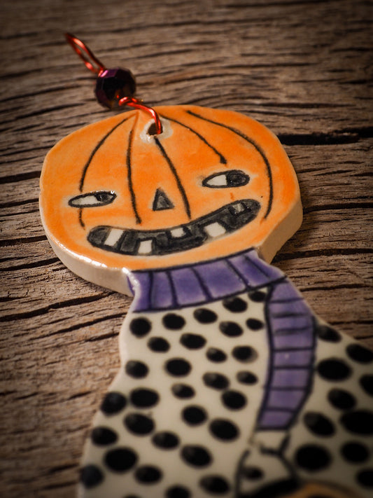 An original handmade Halloween ornament by Idania Salcido, Danita Art. Each ornament is hand carved with pumpkins, witches, cats, jack-o-lanterns and moons. Made with fired glazed ceramics, this little witch, jack-o-lantern and cat is carved with delicate patterns that make each ornament a one of a kind work of art.