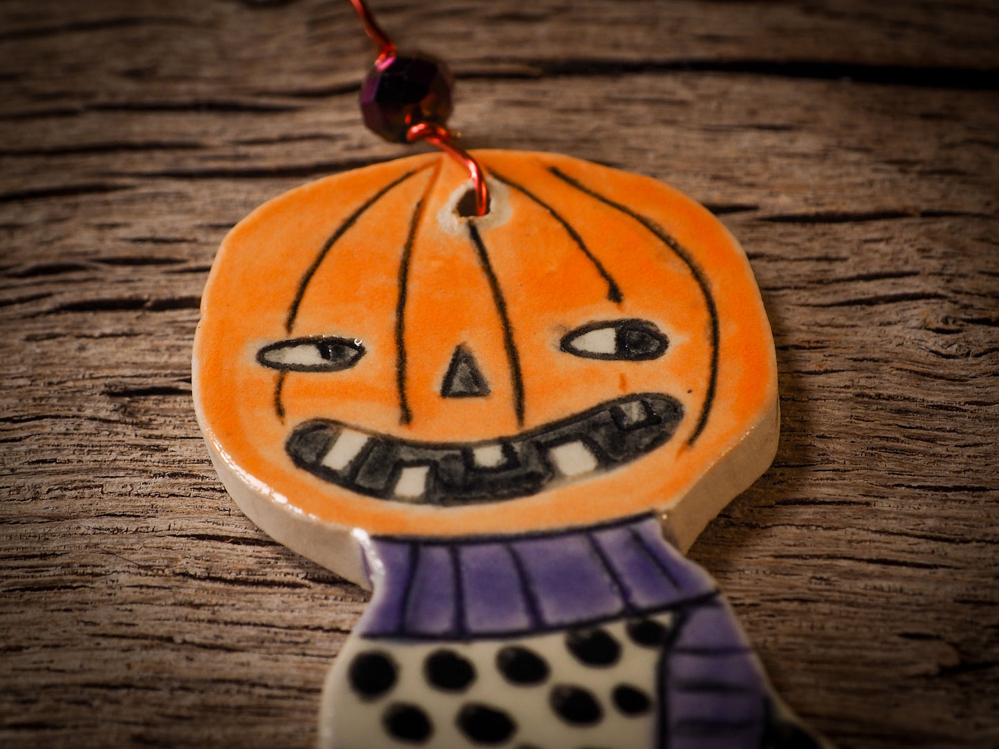 An original handmade Halloween ornament by Idania Salcido, Danita Art. Each ornament is hand carved with pumpkins, witches, cats, jack-o-lanterns and moons. Made with fired glazed ceramics, this little witch, jack-o-lantern and cat is carved with delicate patterns that make each ornament a one of a kind work of art.